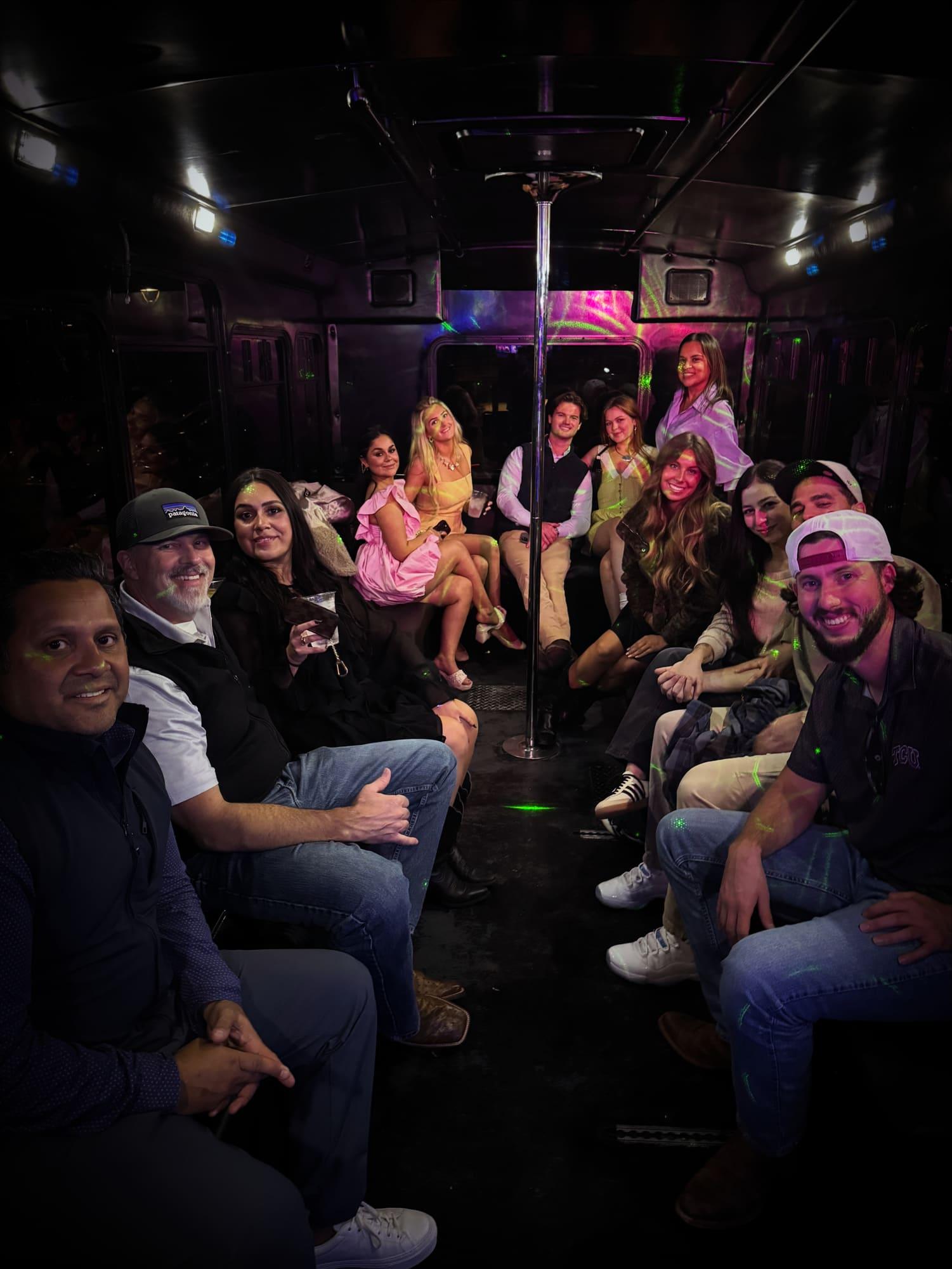 Happy group of guests riding an AUX party bus