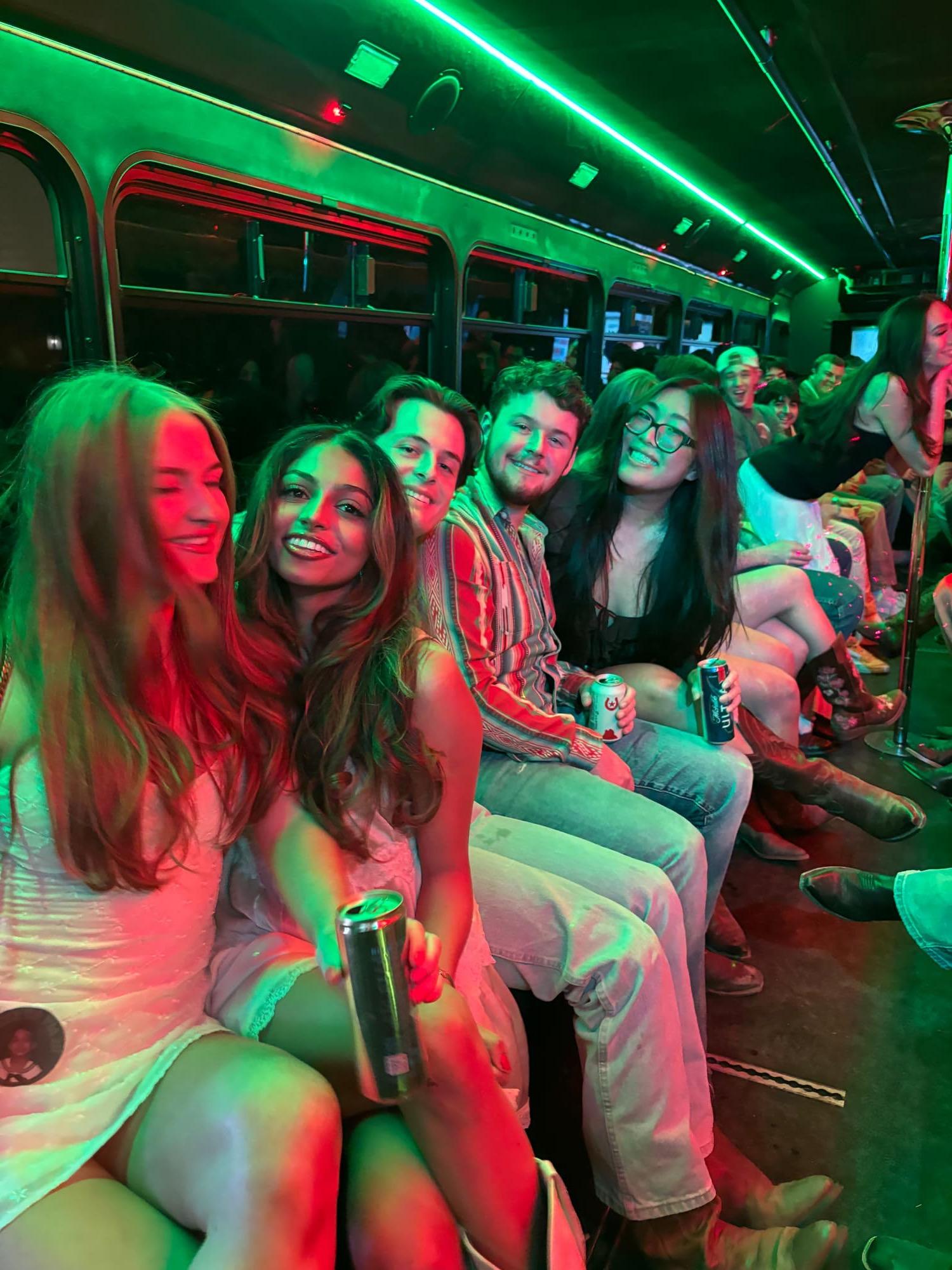 Group of friends on an AUX party bus lit with green lights
