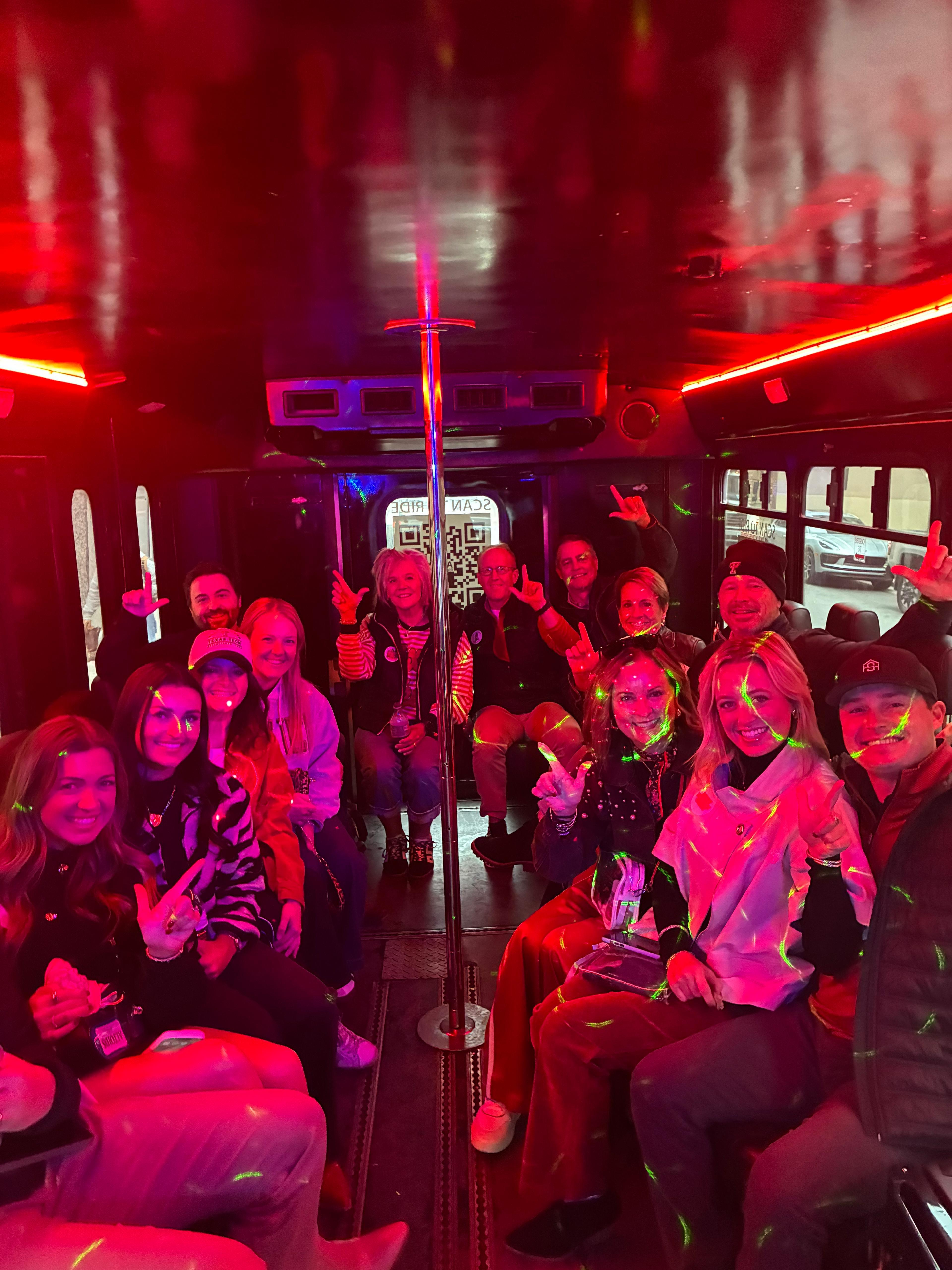 Group of riders celebrating on an AUX party bus