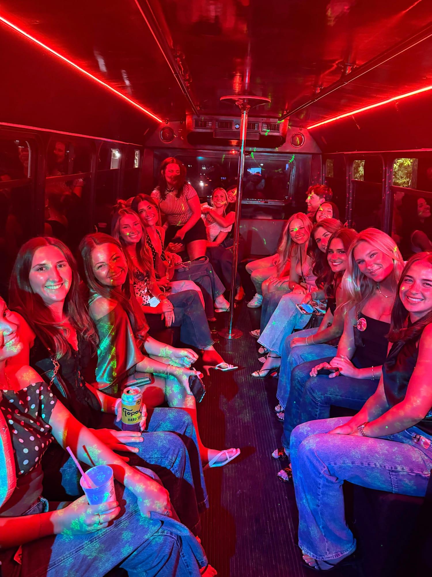 Party in full swing under red lighting on an AUX party bus