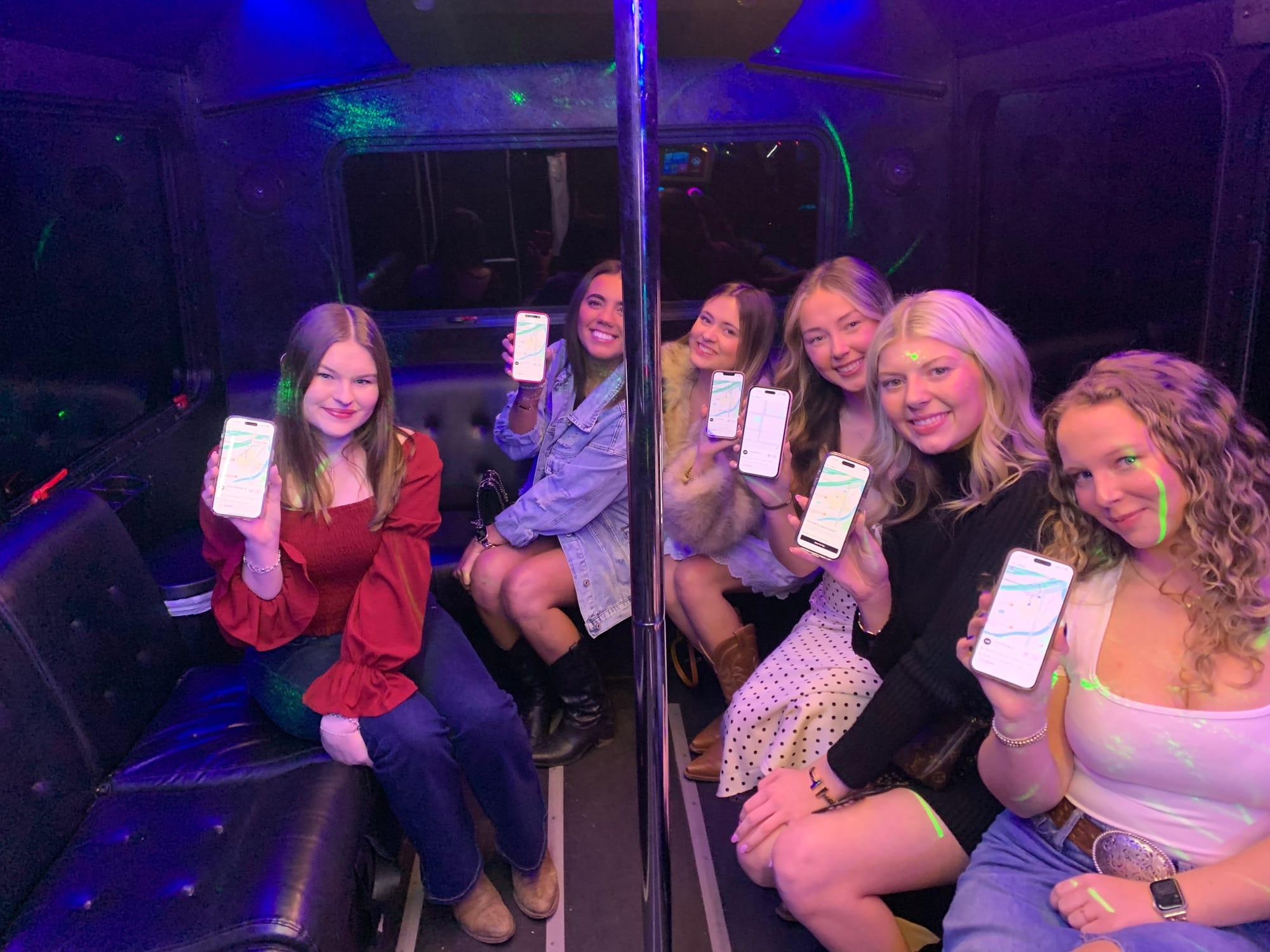 Riders holding up their phones showing the AUX app